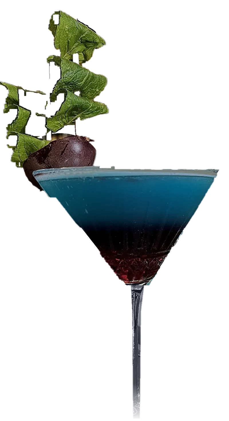 A layered blue and red cocktail in a martini glass, garnished with mint and passion fruit