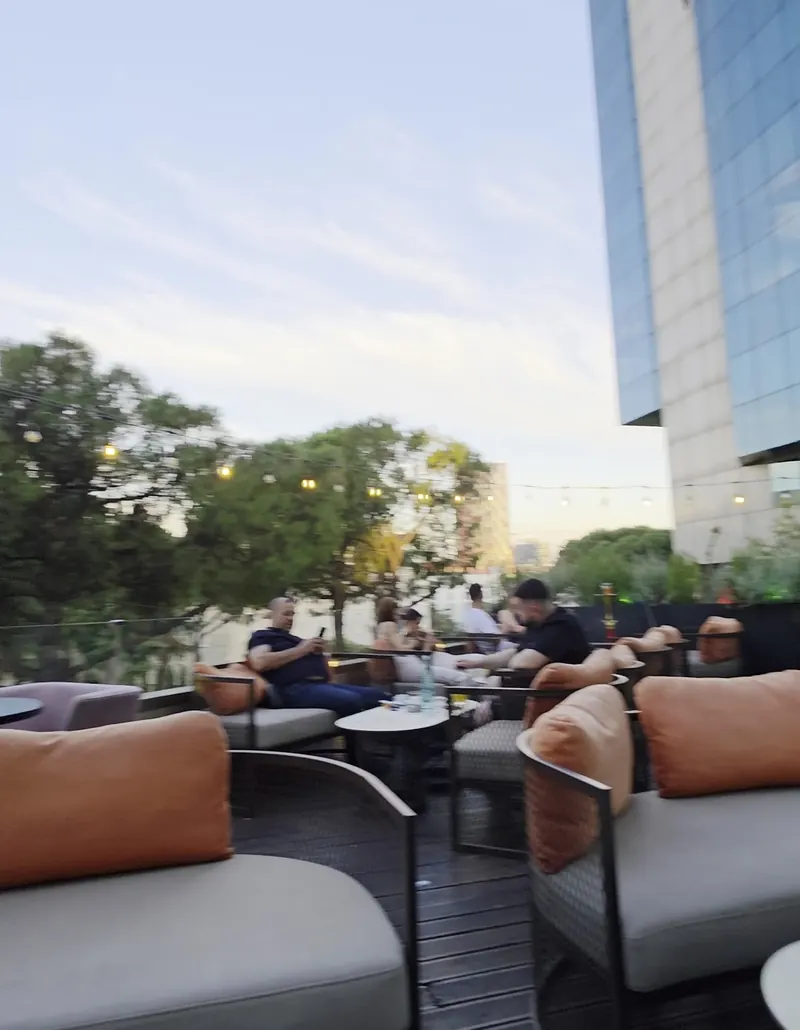 Terrace sofas by day next to the glass façade of the Twin Towers